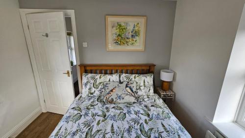 een slaapkamer met een bed met een quilt bij Garden Cottage - Ashover Village near Matlock in Chesterfield