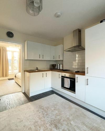 a kitchen with white cabinets and a stove top oven at Cardiff/Penarth Home in Cardiff