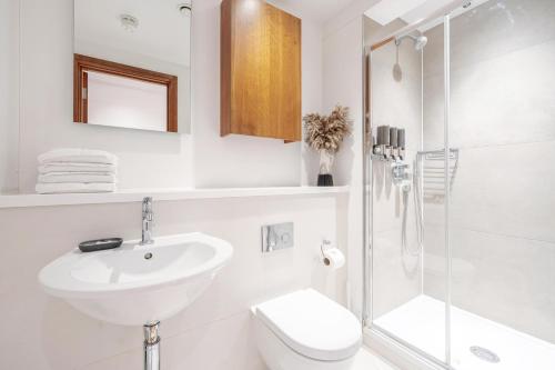 a white bathroom with a sink and a shower at Kula London - Tower Hill in London