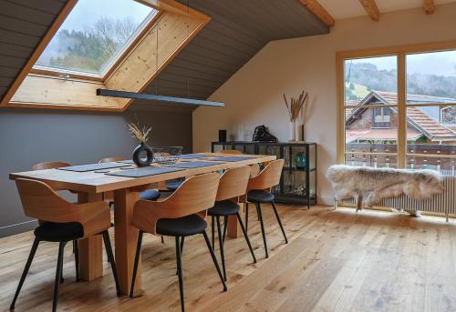 a dining room with a wooden table and chairs at Edelschwarz Allgäu in Oberstaufen