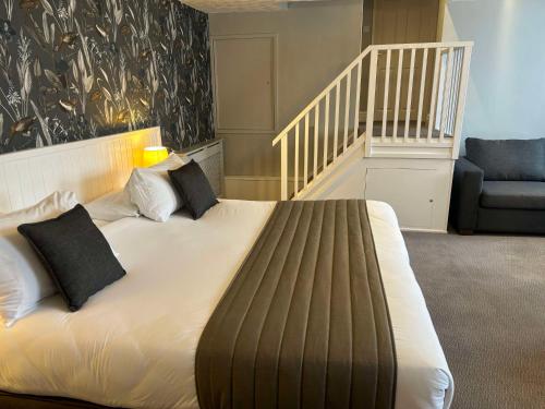a bedroom with a bed with two pillows and a staircase at Best Western Valley Hotel in Ironbridge