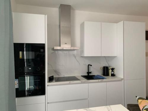 uma cozinha branca com um lavatório e um micro-ondas em Appartement séparé avec parking dans villa em Vilvoorde