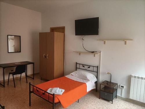 een slaapkamer met een bed, een bureau en een televisie bij CASA D'ALUNZIO - CASE PER FERIE IN OSPITALITA' DIFFUSA in San Marco dʼAlunzio
