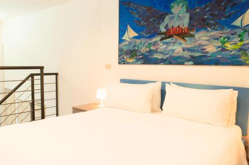 a bedroom with a bed with a painting on the wall at Indipendenza Loft Apartment in Bologna