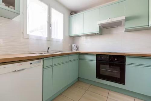 une cuisine avec des armoires vertes et un évier dans l'établissement Chambre cosy en colocation dans une maison, à Champs-sur-Marne