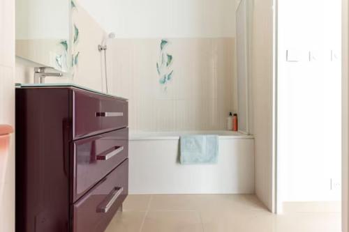 Il comprend une cuisine équipée d'un réfrigérateur violet et une baignoire. dans l'établissement Chambre cosy en colocation dans une maison, à Champs-sur-Marne