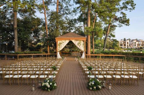 una ceremonia al aire libre con sillas y cenador en The Woodlands Resort, Curio Collection by Hilton, en The Woodlands