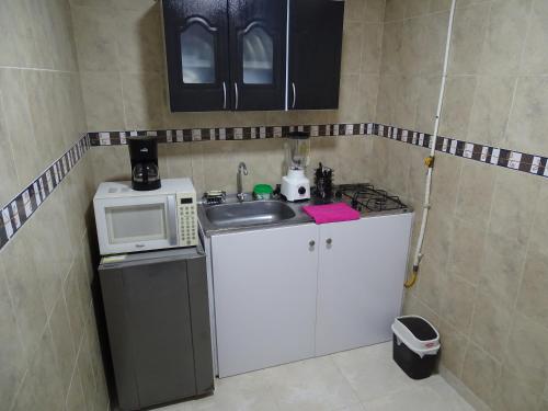 a small kitchen with a sink and a microwave at Apartamento en el sur de Cali in Cali