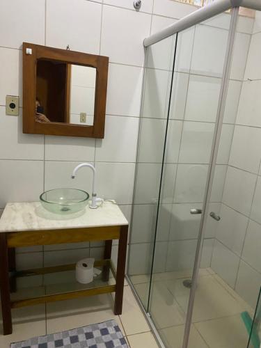 uma casa de banho com um lavatório e uma cabina de duche em vidro. em quintal293 no Recife