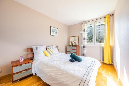 a bedroom with a large white bed and a window at Cosy Appart Paris- la Défense in Courbevoie