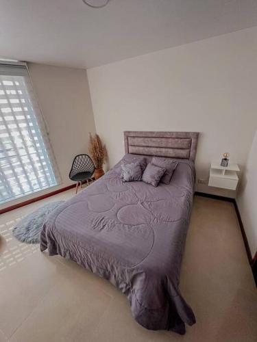una camera con un grande letto e una finestra di Apartamento Duplex en ubicacion privilegiada a Manizales
