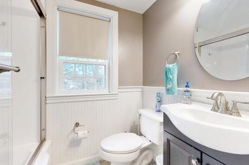 a bathroom with a sink and a toilet and a mirror at Summer on the Cove in West Dennis