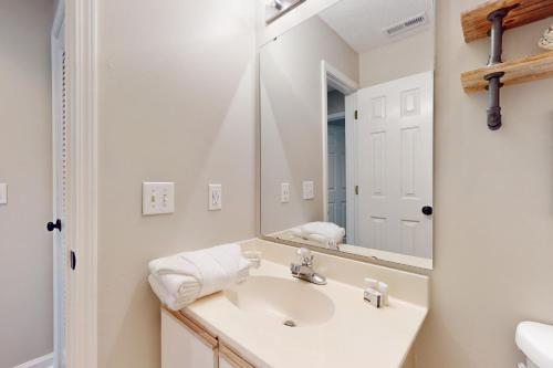 uma casa de banho branca com um lavatório e um espelho em Palmetto Paradise, SC em Pawleys Island