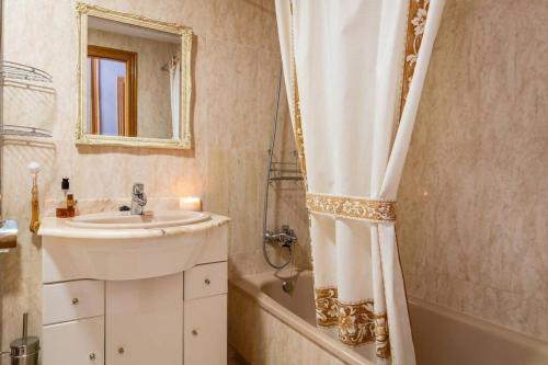 een badkamer met een wastafel en een douchegordijn bij Apartamento familiar centrico in Denia