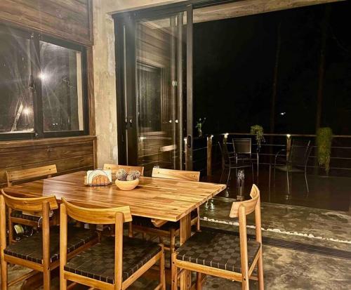 a wooden table and chairs on a patio at Los Helechos 5M in Jarabacoa