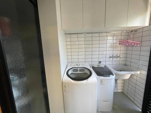a washing machine and a sink in a bathroom at Casa maravilhosa e aconchegante in Itatiba