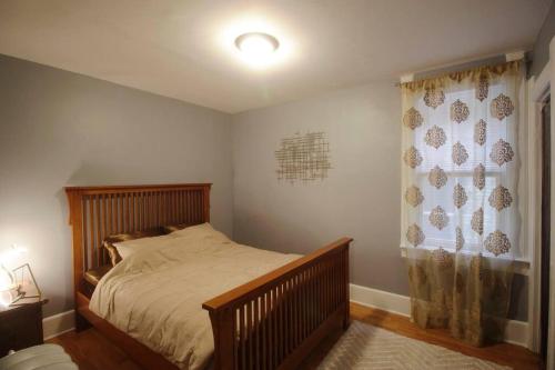 a bedroom with a wooden bed and a window at Renovated Brady St. Classic in Milwaukee