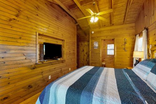 a bedroom with a bed in a log cabin at Lazy Bear Creek Lodge in Blairsville