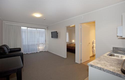 a living room with a couch and a room with a bed at Atrium On Ulster in Hamilton