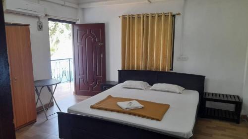 a bedroom with a bed with a towel on it at Downing Street inn a perfect homestay in Port Blair