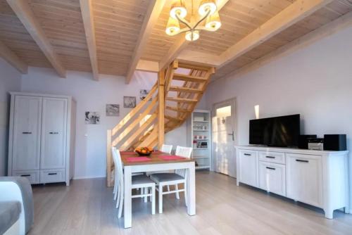 a living room with a table and a staircase at Domek A 145 Miód Malina- Kaszubska Ostoja in Barkocin