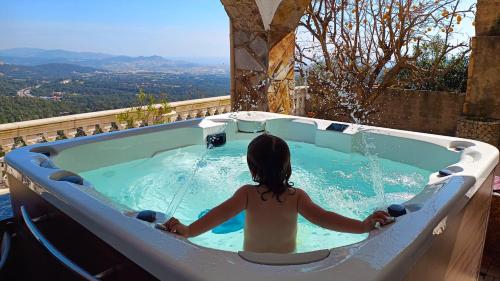 uma menina sentada numa banheira de hidromassagem em Villa Cariño em Sant Genís de Palafolls