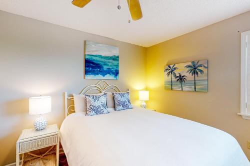 1 dormitorio con cama blanca y ventana en Stay Salty, en Myrtle Beach