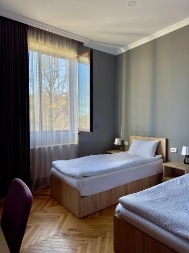 ein Schlafzimmer mit zwei Betten und einem Fenster in der Unterkunft Shanshe in Gurjaani