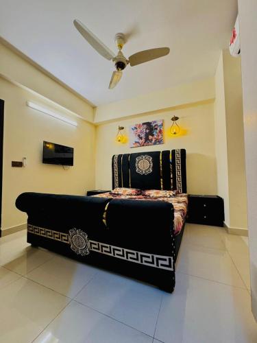 een bed in een kamer met een plafondventilator bij The Iconic 1BHK, Gulber Greens Islmabad in Rawalpindi