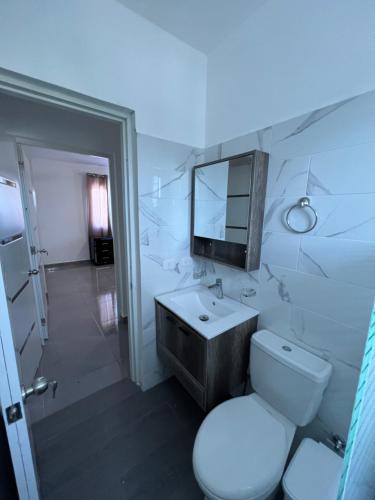 a bathroom with a toilet and a sink and a mirror at Papillo Tower in Bayahibe