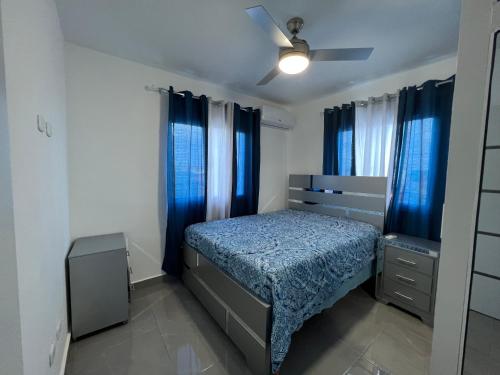 a bedroom with a bed and blue curtains at Papillo Tower in Bayahibe