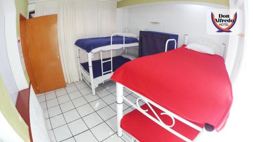 um pequeno quarto com 2 beliches e uma mesa vermelha em RIVERA habitacion#1A em Guanajuato