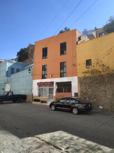 um carro preto estacionado em frente a um edifício em RIVERA habitacion#1A em Guanajuato