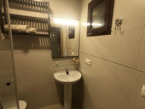 een kleine badkamer met een wastafel en een spiegel bij Apartamento Carteya in Algeciras