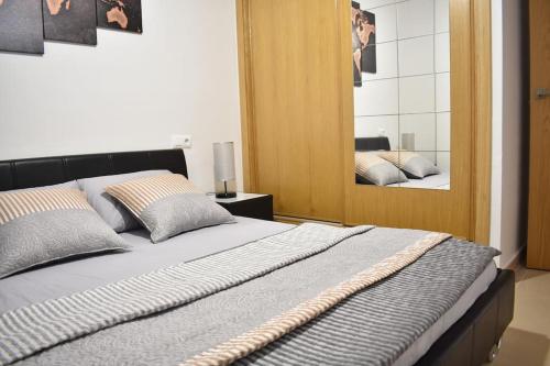 een slaapkamer met een groot bed en een spiegel bij Apartamento Carteya in Algeciras