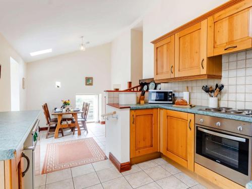 a kitchen with wooden cabinets and a table in it at 1 Bed in Builth Wells BN029 in Llanafan-fawr