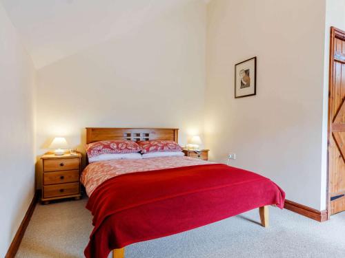 a bedroom with a bed with a red blanket at 1 Bed in Builth Wells BN029 in Llanafan-fawr