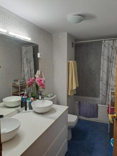 een badkamer met 2 wastafels, een toilet en een bad bij NOVA PINEDA PORT AVENTURA in La Pineda