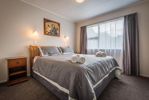ein Schlafzimmer mit einem Bett mit zwei Handtüchern darauf in der Unterkunft Beez Kneez in Rotorua
