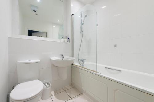 een witte badkamer met een toilet en een wastafel bij Modern Luxury Apartment by Bow Road Station in Londen