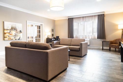 a living room with a couch and a chair at Crowne Plaza Fredericton Lord Beaverbrook by IHG in Fredericton