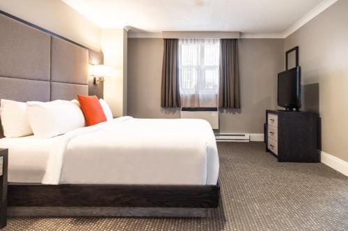 a hotel room with a bed and a flat screen tv at Crowne Plaza Fredericton Lord Beaverbrook by IHG in Fredericton