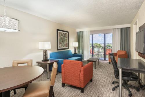 プランテーションにあるHoliday Inn Express Hotel & Suites Ft. Lauderdale-Plantation, an IHG Hotelのリビングルーム(ソファ、テーブル、椅子付)