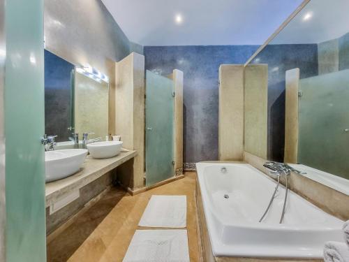 een badkamer met 2 wastafels en een bad bij Villa Soraya/Noor Hotel & Spa in Marrakesh
