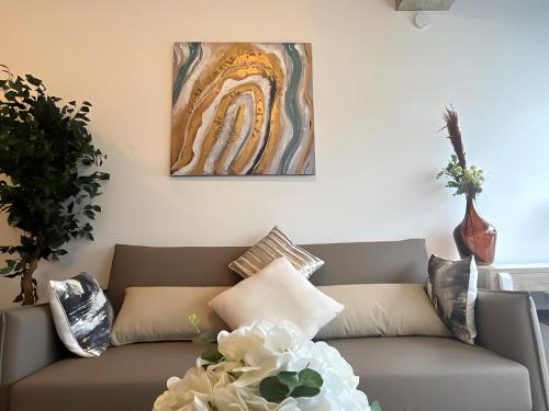 a living room with a couch and a painting on the wall at 1BR Luxury Flat at Train station - Long stays welcome - just ask in Milton Keynes