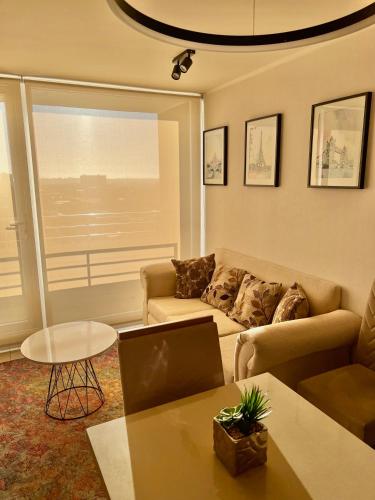 a living room with a couch and a table at Apartamentos Concepción Centro in Concepción