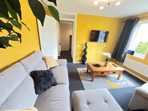 uma sala de estar com um sofá branco e uma mesa em 1BR Flat MK Centre - Free Parking - Private Garden - Long stays welcome - just ask em Milton Keynes