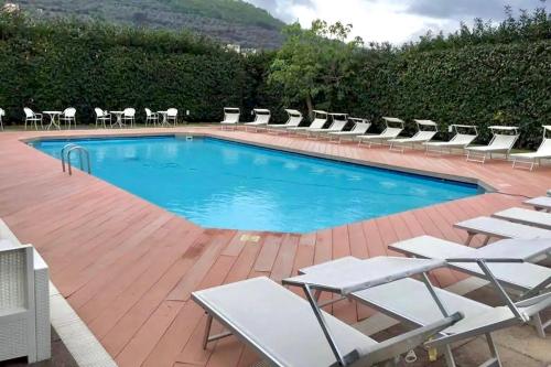 una piscina con sillas y un montón de plantas en Villa della Porta, Amalfi Coast - Historical heritage, en Vico Equense