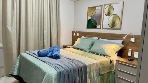 Un dormitorio con una cama con toallas azules. en Edf Duetto 2 QTS c/ar, en Maceió