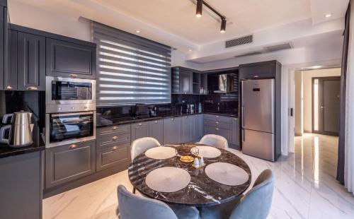 a kitchen with a table and some chairs and a kitchen withuclear at Royal Villas in Kérynia